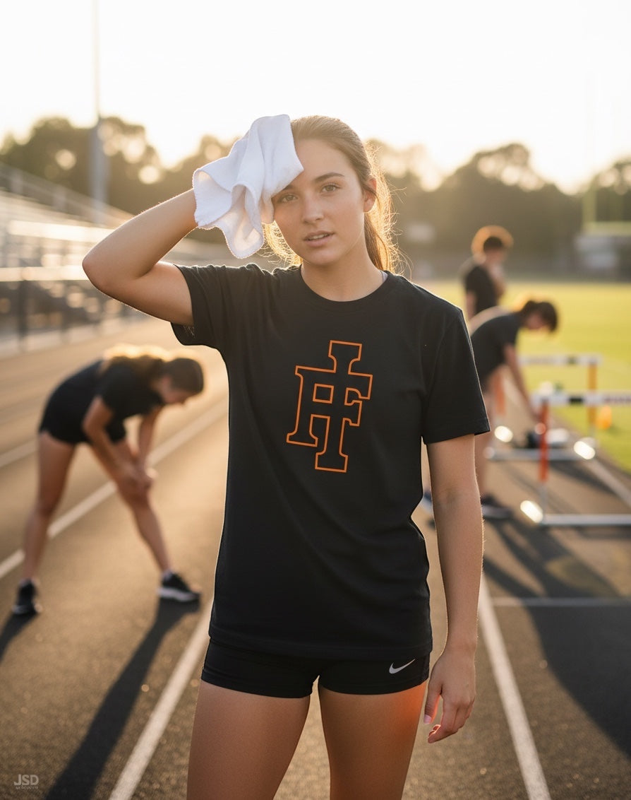 JSD Apparel black premium crewneck tee with orange IF logo worn by a female athlete on a track at sunset