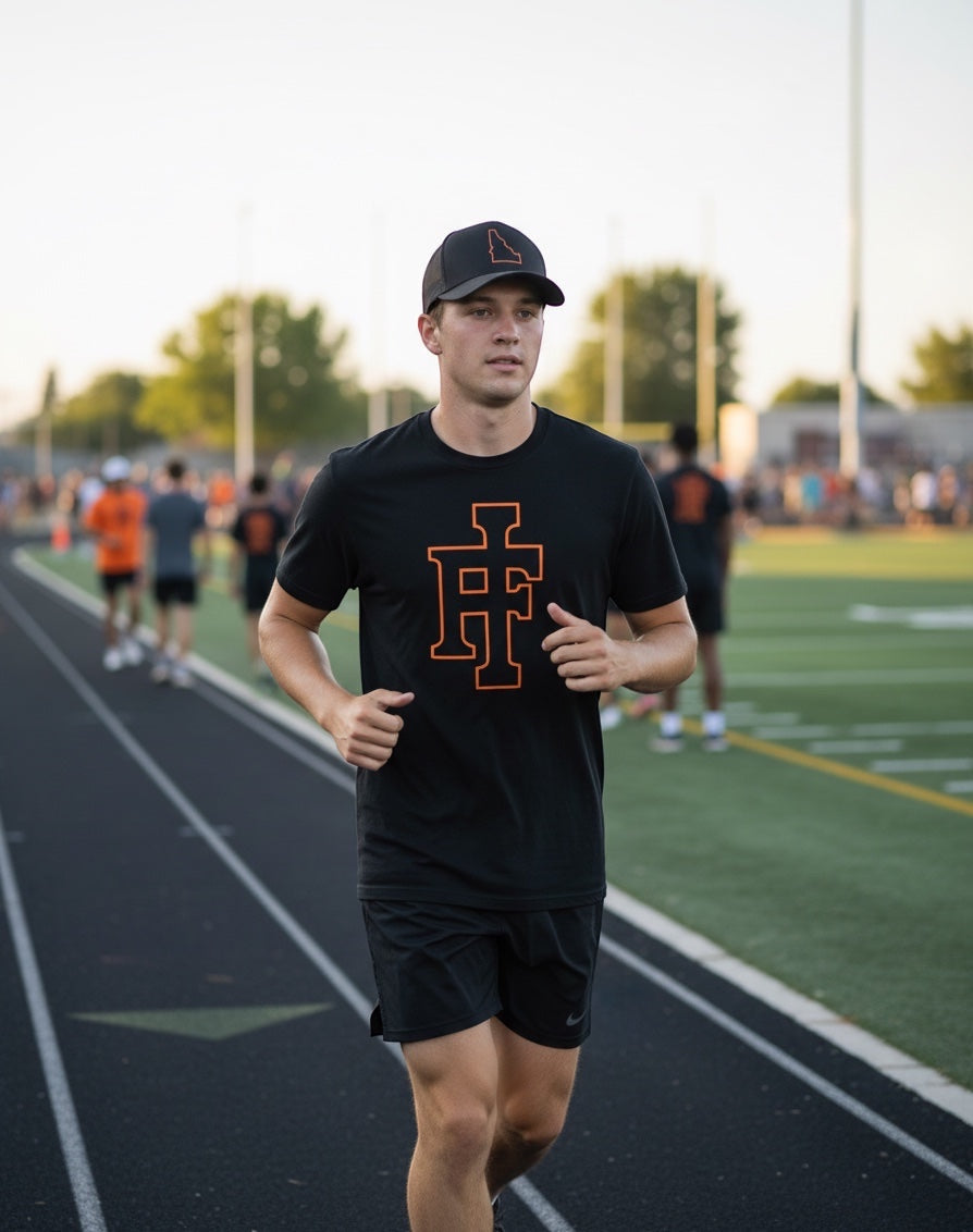 JSD Apparel black premium crewneck t-shirt with orange IF logo worn by a man running on a track at sunset