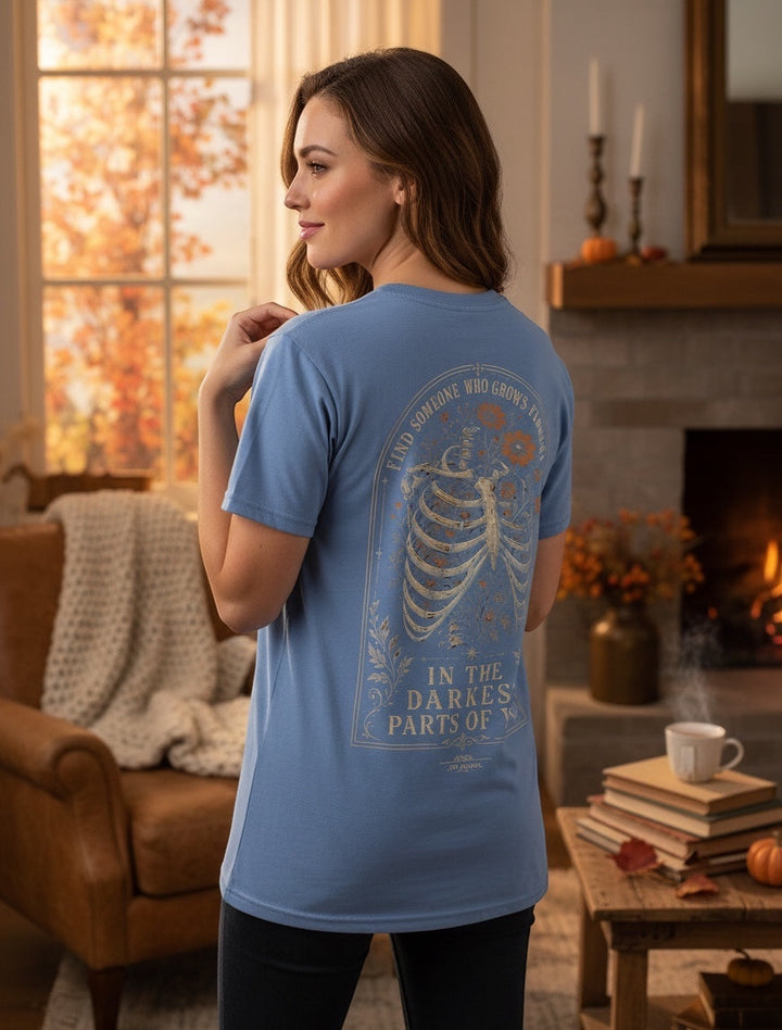 JSD Apparel blue Comfort Colors unisex tee with vintage skeletal floral back graphic in a cozy living room setting.