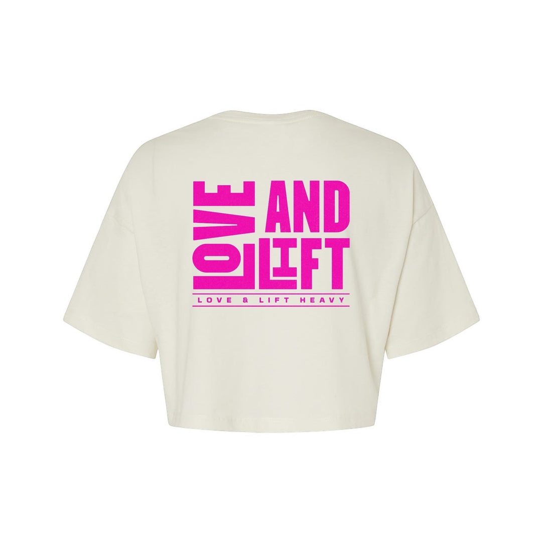 JSD Apparel cream cropped t-shirt with pink "LOVE AND LIFT HEAVY" graphic on back. 100% cotton.