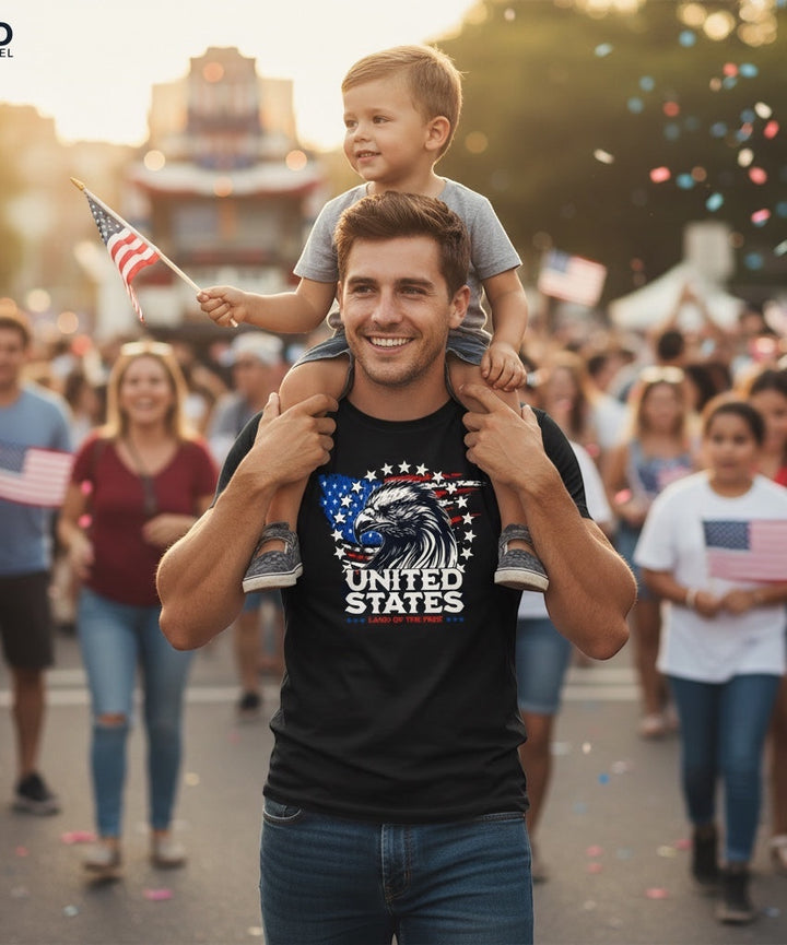 Man wearing JSD Apparel black Land of The Free Eagle tee with child on shoulders at a patriotic parade