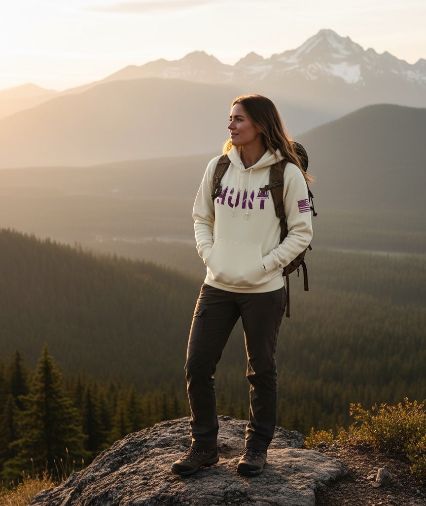 JSD Apparel unisex heavy weight pullover hoodie with Hunt graphic, worn by a woman hiking in the mountains.