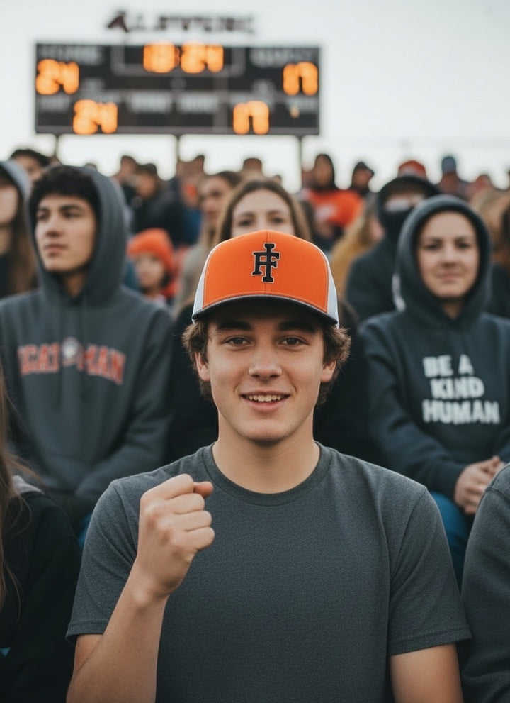 JSD Apparel Idaho Falls Tigers Richardson 112 snapback hat in orange and white with IF logo worn by a fan at a game