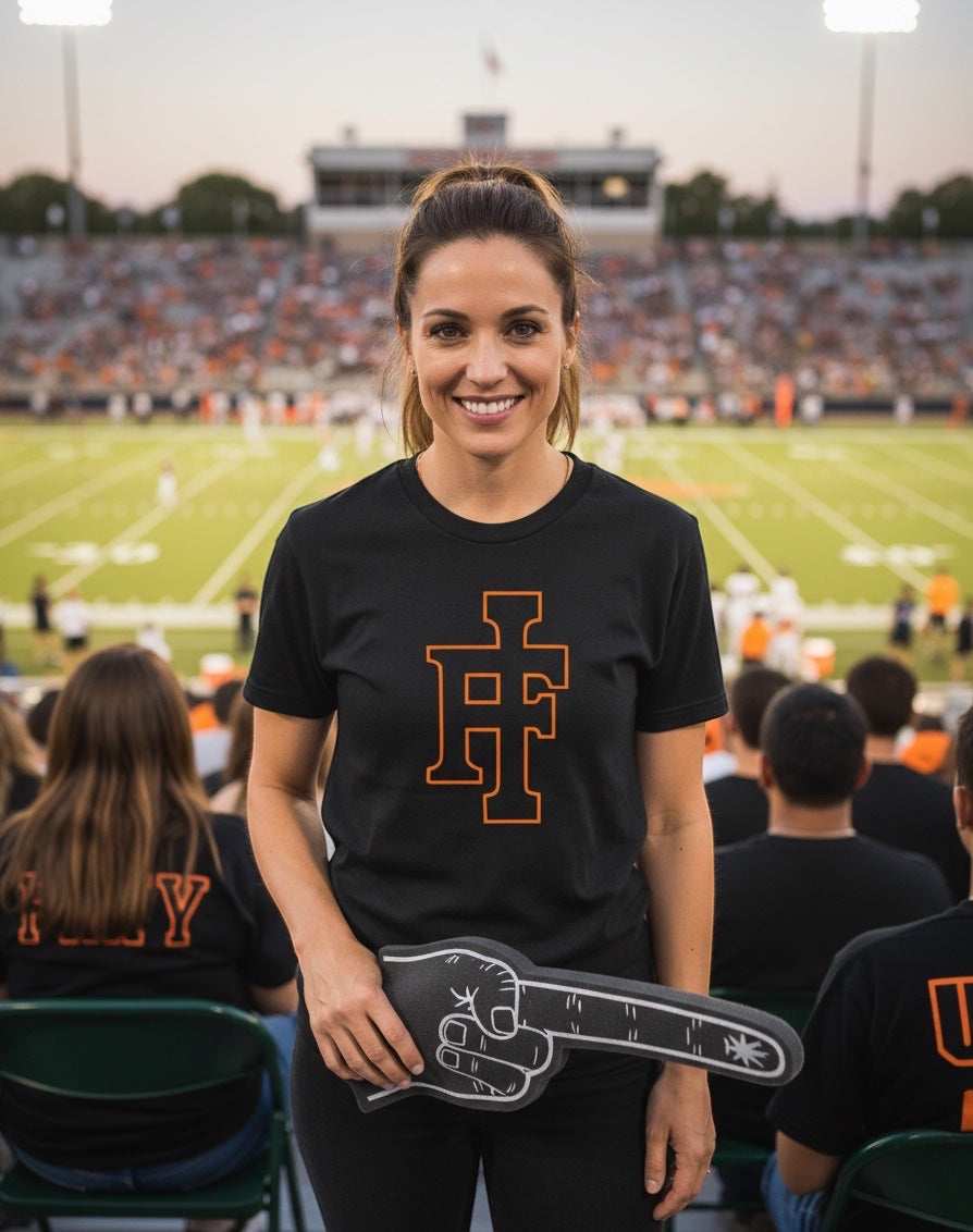 JSD Apparel black premium crewneck tee featuring an orange Idaho Falls IF logo worn by a woman at a football stadium