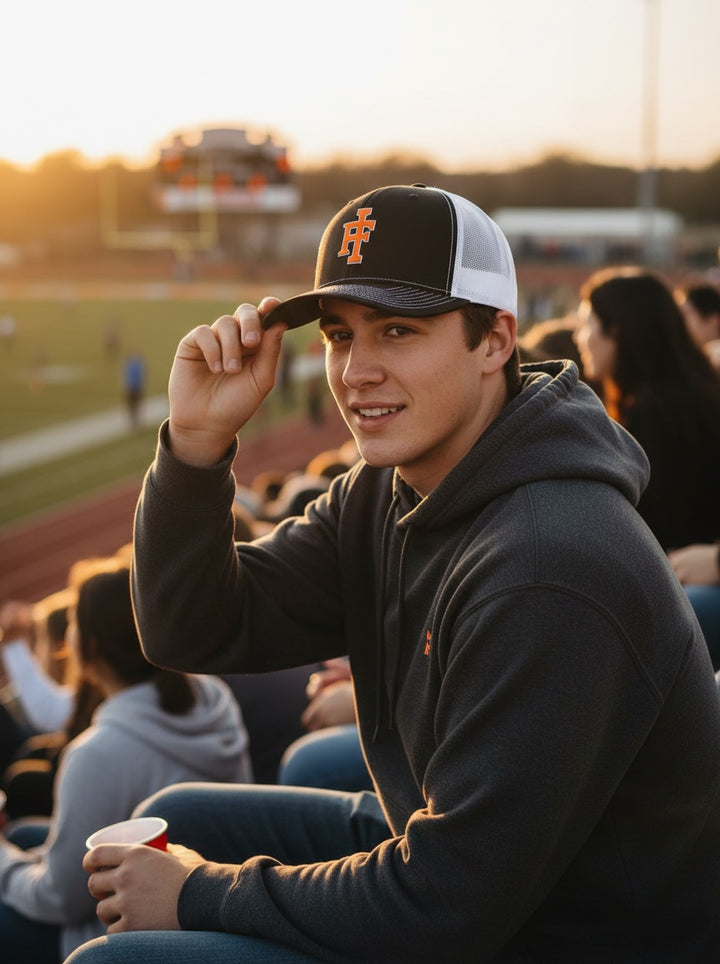 JSD Apparel Idaho Falls Tigers Richardson 112 trucker hat in black and white with orange IF logo on a young man