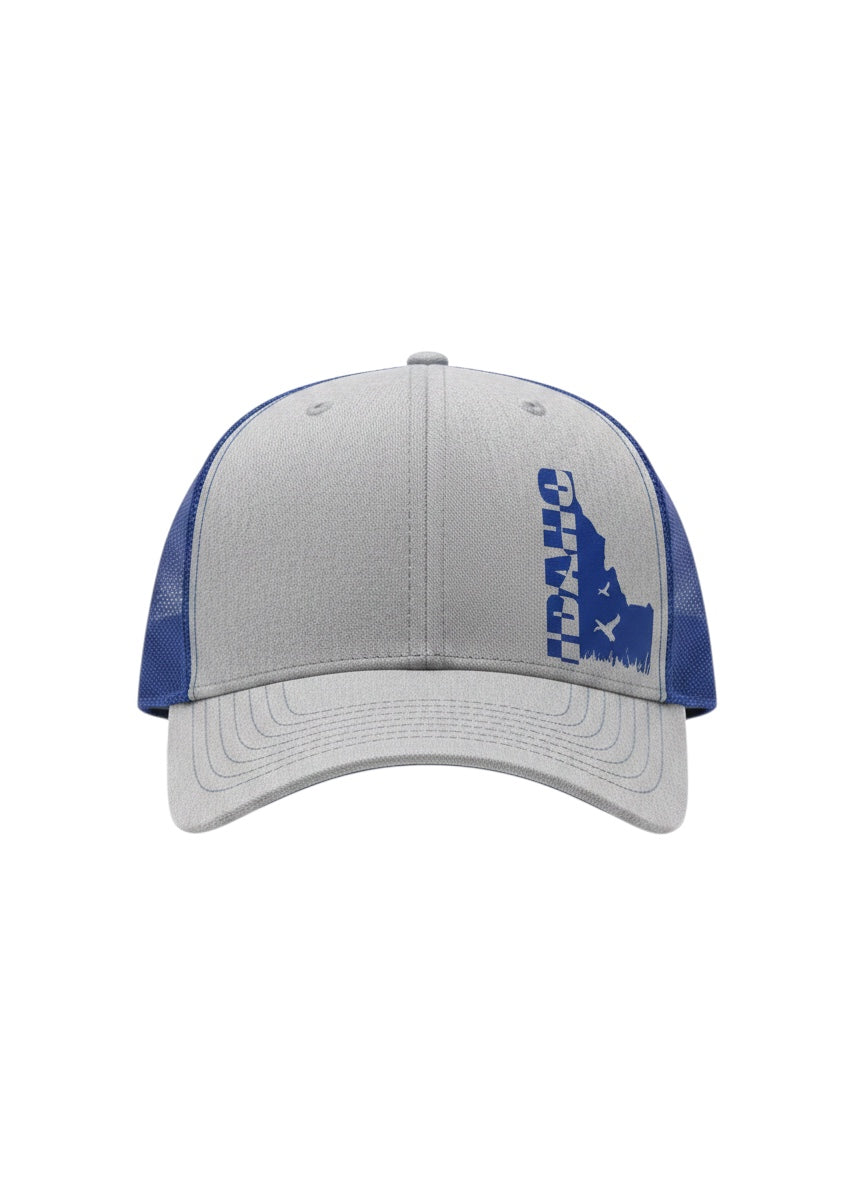 JSD Apparel Idaho Flyway trucker hat in heather gray with royal blue mesh back and Idaho state silhouette graphic.