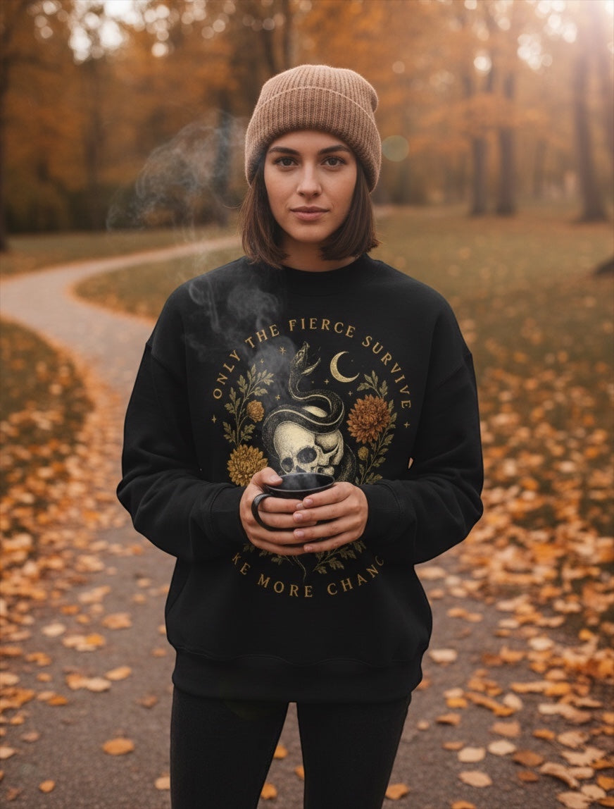 JSD Apparel mock neck sweatshirt with skull and serpent graphic worn by a woman in a beanie in an autumn park.