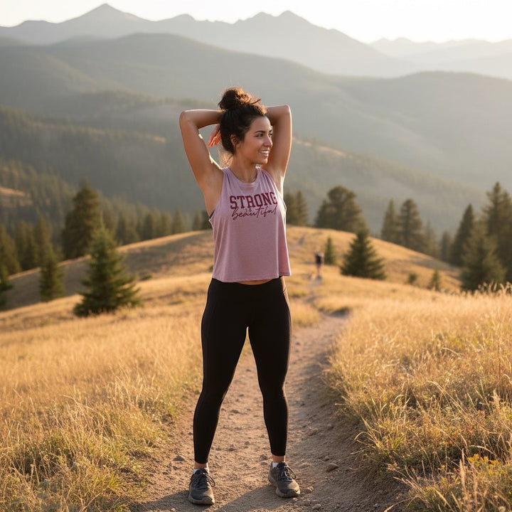 JSD Apparel orchid pink racerback cropped tank top with "STRONG IS BEAUTIFUL" graphic, made of cotton-poly blend.