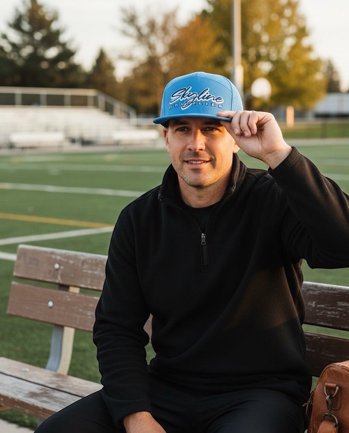 Man wearing a light blue JSD Apparel Skyline Grizzlies performance snapback cap with perforated side panels on a field