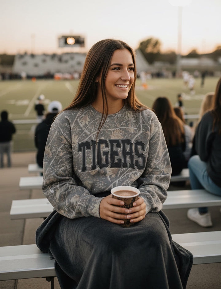 JSD Apparel Tigers crewneck sweatshirt in gray marble wash with black collegiate lettering worn by a smiling woman
