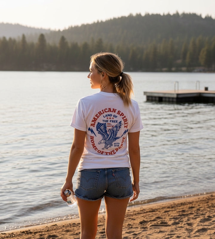 JSD Apparel white cotton t-shirt with vintage eagle and patriotic American spirit graphic on the back at a lake
